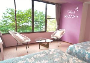 大岛Hotel MOANA絶景オーシャンビューカフェラウンジ的酒店客房设有两把椅子和紫色墙壁