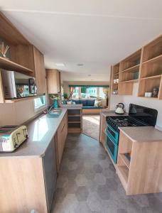 HumberstonSpacious Caravan - Thorpe Park Cleethorpes的厨房配有木制橱柜和炉灶烤箱。