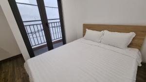 河内Era Apartment Khuc Thua Du的卧室设有白色的床和大窗户