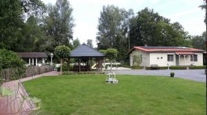 Hechtel-EkselCosy-Cottage的一个带凉亭和房子的庭院