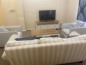 纳拉布赖Gallipoli House- The Loft Apartment的客厅配有2张沙发和1台平面电视