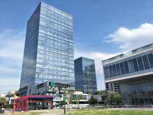 广州广州丽途国际公寓酒店（神舟路地铁站店）的两座高楼前方的一座高玻璃建筑