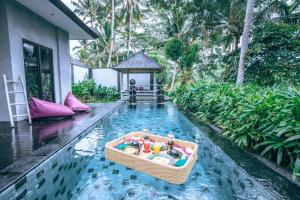 BedahuluCapung Asri Eco Luxury Resort with Private Pool Villas的游泳池中间的小船