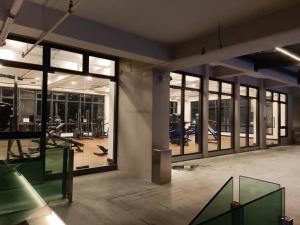 梳邦再也The Grand SS15 2BRs Infinity Pool 200Mbps WiFi的一个带大型玻璃窗的健身房和一个带健身器材的健身房