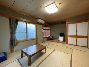 白马村Hotel Sejour Mint in Hakuba的客厅配有桌子和窗户