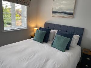 亨斯坦顿The Sorting House的卧室配有白色床和2个绿色枕头