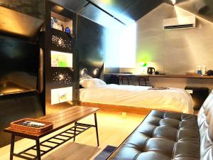 WakimachiADLIV/Factry Stay/工場に泊まれる的一间卧室配有一张床、一张沙发和一张桌子
