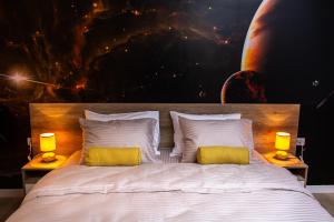贝尔格莱德Galaxy Apartments的一间卧室配有一张大床和两张黄色枕头