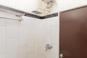 贝克西RedDoorz Syariah near Green Park Jatiwarna的浴室设有白色瓷砖淋浴。