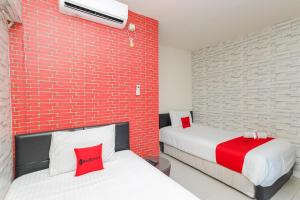 贝克西RedDoorz Syariah near Green Park Jatiwarna的砖墙客房的两张床