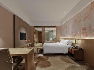 福州福州融侨皇冠假日酒店的配有一张床和一张书桌的酒店客房