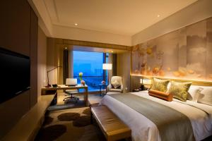 福州福州融侨皇冠假日酒店的配有一张床、一张书桌和一扇窗户的酒店客房