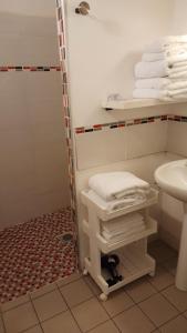圣艾米隆曼萨尔的酒店的带淋浴、水槽和毛巾的浴室