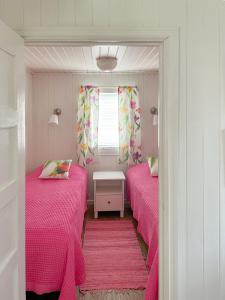 玛丽港Strandbergs Stugor的小客房内的两张床和粉红色床单