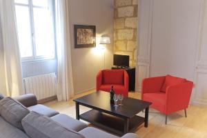波尔多Chartres - Appartement 1 chambre avec ascenseur的客厅配有2把红色椅子和咖啡桌
