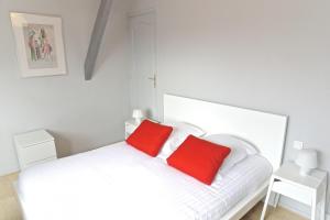 波尔多Chartres - Appartement 1 chambre avec ascenseur的一张带两个红色枕头的白色床