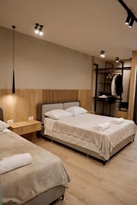 斯库台Sol Hotel的一间卧室设有两张床和一个衣服架子。