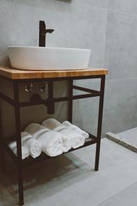 斯库台Sol Hotel的一间带水槽和架子毛巾的浴室