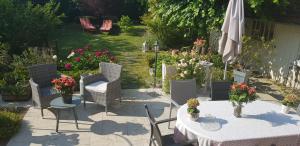 Vaires-sur-MarneLe Vieux Tilleul的庭院配有桌椅和遮阳伞。