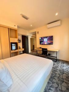 吉隆坡和平酒店的酒店客房设有一张白色大床和一张书桌