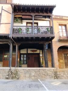 卡韦苏埃拉德尔瓦列CASA RURAL LOS PORTALES Valle del Jerte的一座带鲜花阳台的建筑