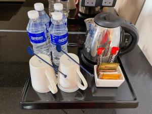 马六甲海峡套房酒店的一个带瓶装水和茶壶的托盘