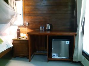 珀尼达岛The Valley Green Cottage的一张木桌、一台电视和一个床头柜