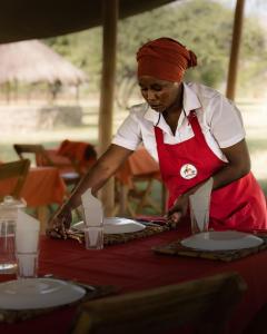 MtowabagaLake Natron Maasai giraffe eco Lodge and camping的女人站在桌子上,边边边摆边