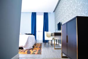 雅温得Djeuga Palace Hotel的配有一张床和一张书桌的酒店客房
