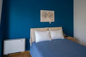 比雷埃夫斯Maxblue 2的蓝色的卧室,配有床和蓝色的墙壁