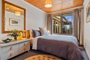 Alonnah曼荼罗布鲁尼岛度假屋的一间卧室设有一张床和一个窗口