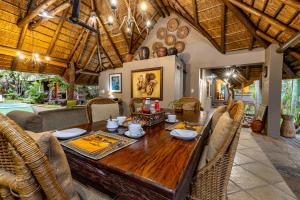 马里兰Mhlati Guest Cottages的一间带木桌和椅子的用餐室