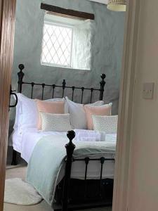 威弗利斯科姆Luxury Cottage in Somerset的一间卧室配有带粉色和白色枕头的床