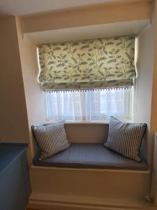 威弗利斯科姆Luxury Cottage in Somerset的窗前带两个枕头的靠窗座位