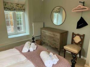 威弗利斯科姆Luxury Cottage in Somerset的一间卧室配有带毛巾和镜子的床