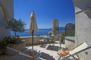 普莱伊亚诺Villa Il Frantoio and Lilmar的庭院配有桌子、遮阳伞和椅子
