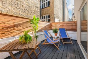 伦敦StayLux Kensington的阳台上配有两把椅子和一张木桌