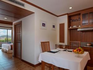 芭东海滩Sun Hill Hotel Patong的厨房配有一张桌子,上面放着一碗水果