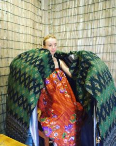 暹粒Hostel Goen -Japanese hostel-的一个小女孩坐在一堆毯子里