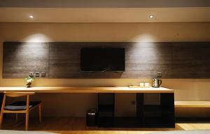 嘉义市嘉义观止饭店的客房设有一张桌子,墙上配有电视