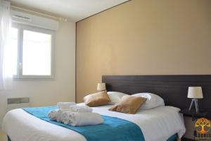 格朗德康迈西阿多尼斯格兰营地公寓 - 德索拉岛住宅的一间卧室配有一张大床和毛巾