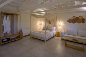米蒂利尼奥基斯优雅小别墅酒店的一间卧室配有天蓬床和沙发