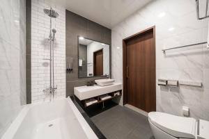 木浦市Hotel Demer Mokpo的带浴缸、盥洗盆和卫生间的浴室