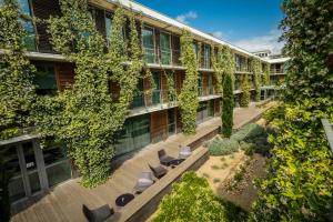 蒙彼利埃蒙彼利埃万怡酒店的公寓大楼设有带椅子和植物的庭院