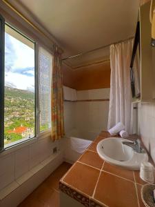 旺斯米拉玛酒店的一间带水槽和浴缸的浴室以及窗户。