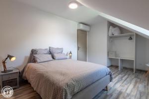 杜萨尔Gite Annecy 201- Au Royaume des Castors - Appt 201的一间白色的卧室,配有床和楼梯