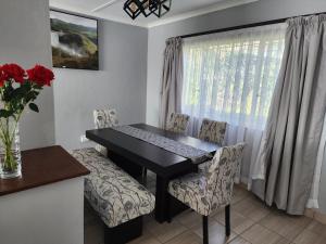 马塞卢Motebong Villa的一间带桌椅和窗户的用餐室
