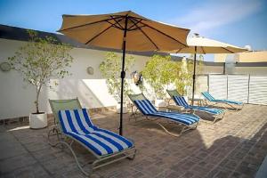 迪拜凡尔赛拉维兹酒店的庭院里摆放着一组椅子和一把遮阳伞