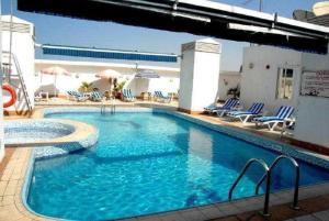 迪拜凡尔赛拉维兹酒店的一个带蓝色椅子和遮阳伞的大型游泳池