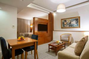 安曼Sadeen Amman Hotel的客厅配有沙发和桌子